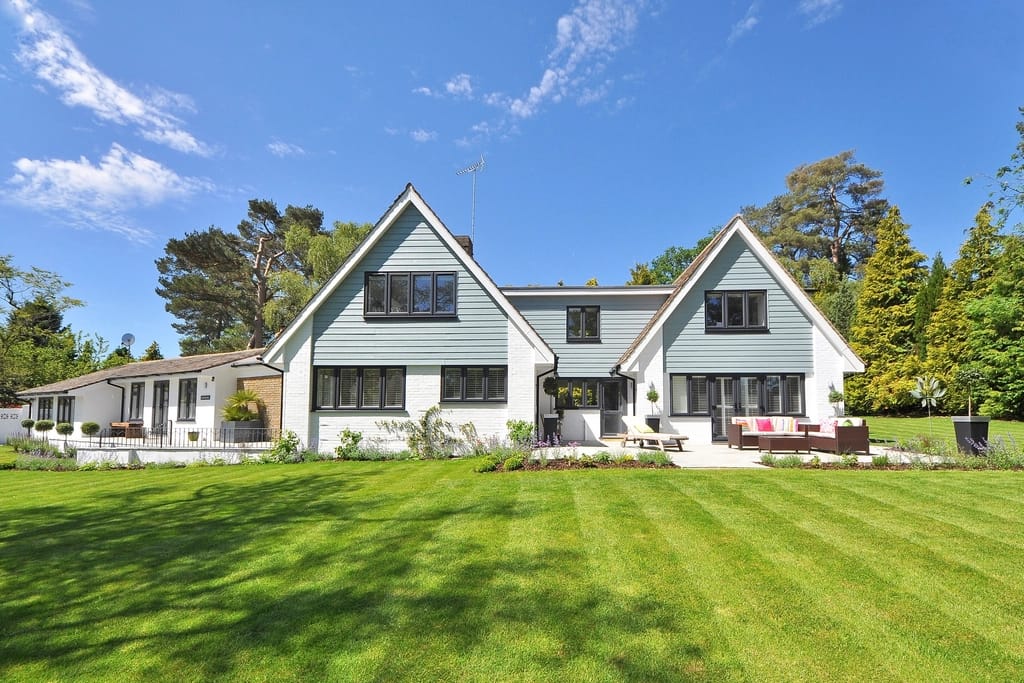 White coastal farmhouse with a green lawn