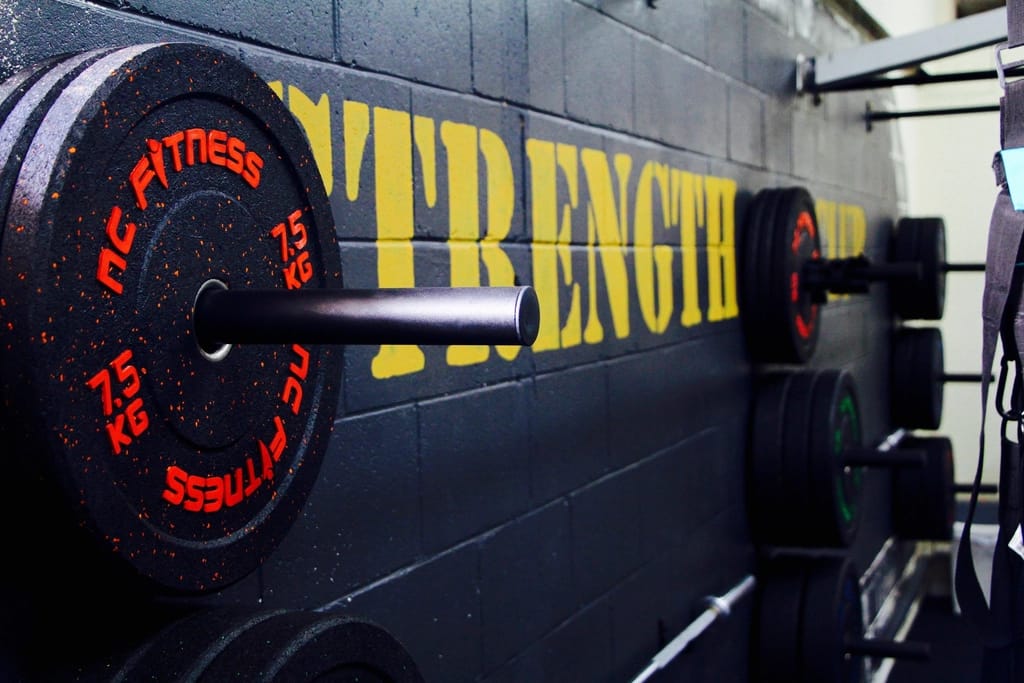 Strength gym with plates and a painted wall
